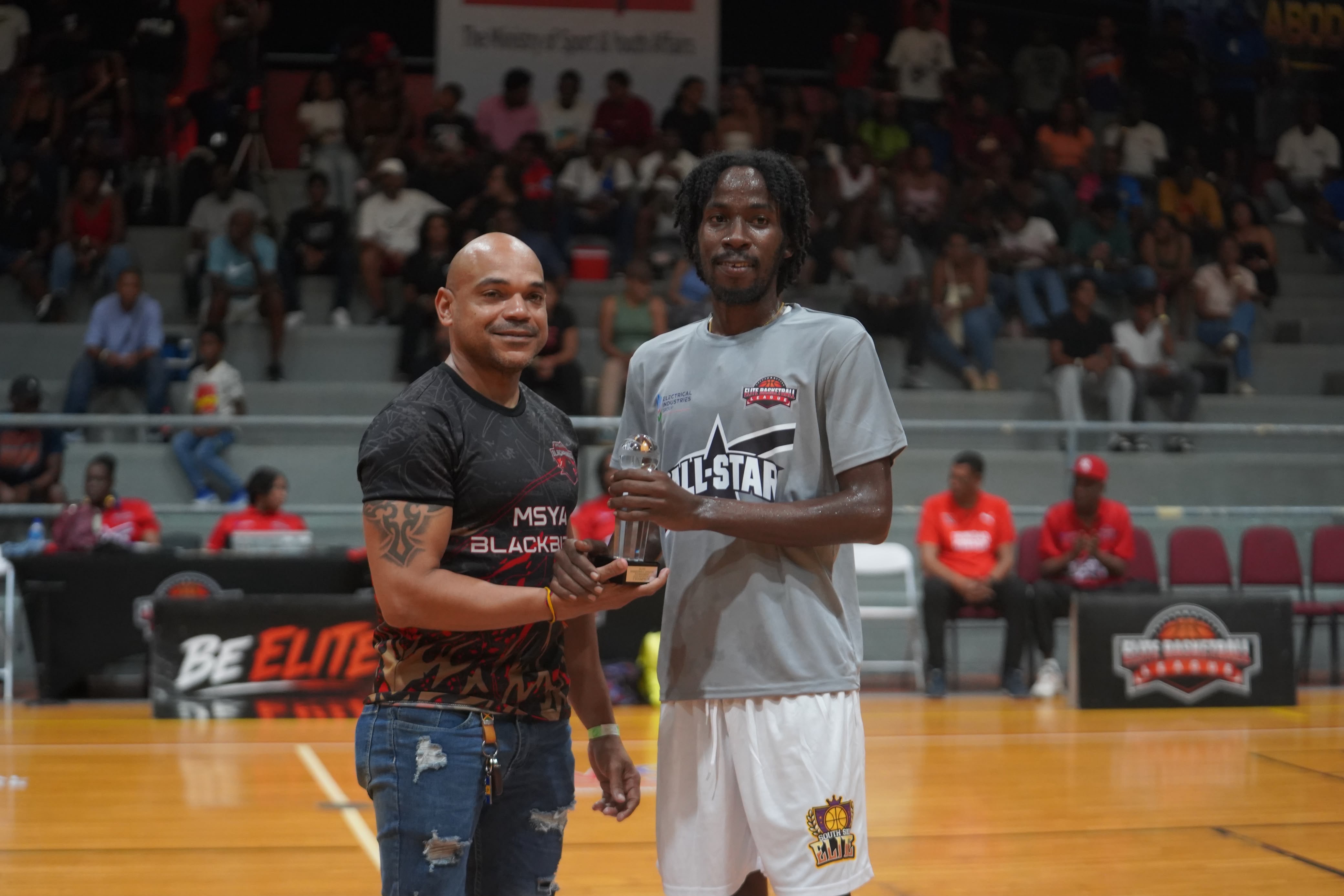 Ronson Hackshaw, Acting Director at the Ministry of Sport and Youth Affairs, presents Ahkeem “Fato” Boyd (right) with his three-point shootout trophy.